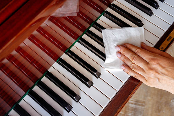 Mit einem Tuch über die Klaviatur streichen – Anja Stutz Klavierbaumeisterin, Reparaturen und Stimmungen für Ihr Klavier, Cembalo und Ihren Flügel